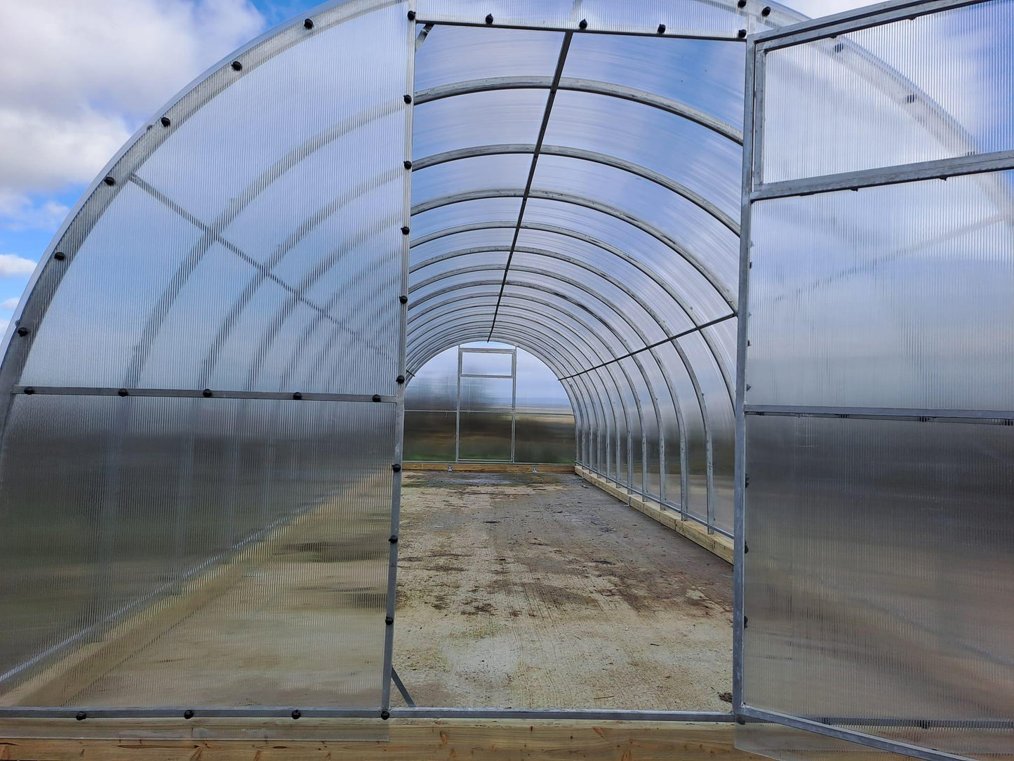 Polycarbonate greenhouse 3m x 10m interior view showing steel frame and polycarbonate panels.